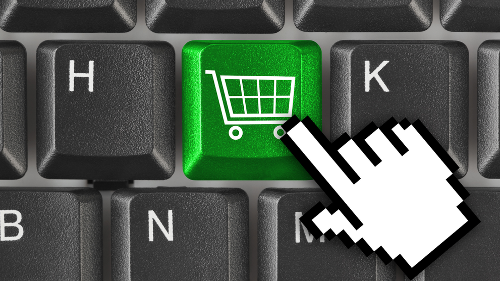 Hand cursor pointing at green shopping cart button on keyboard